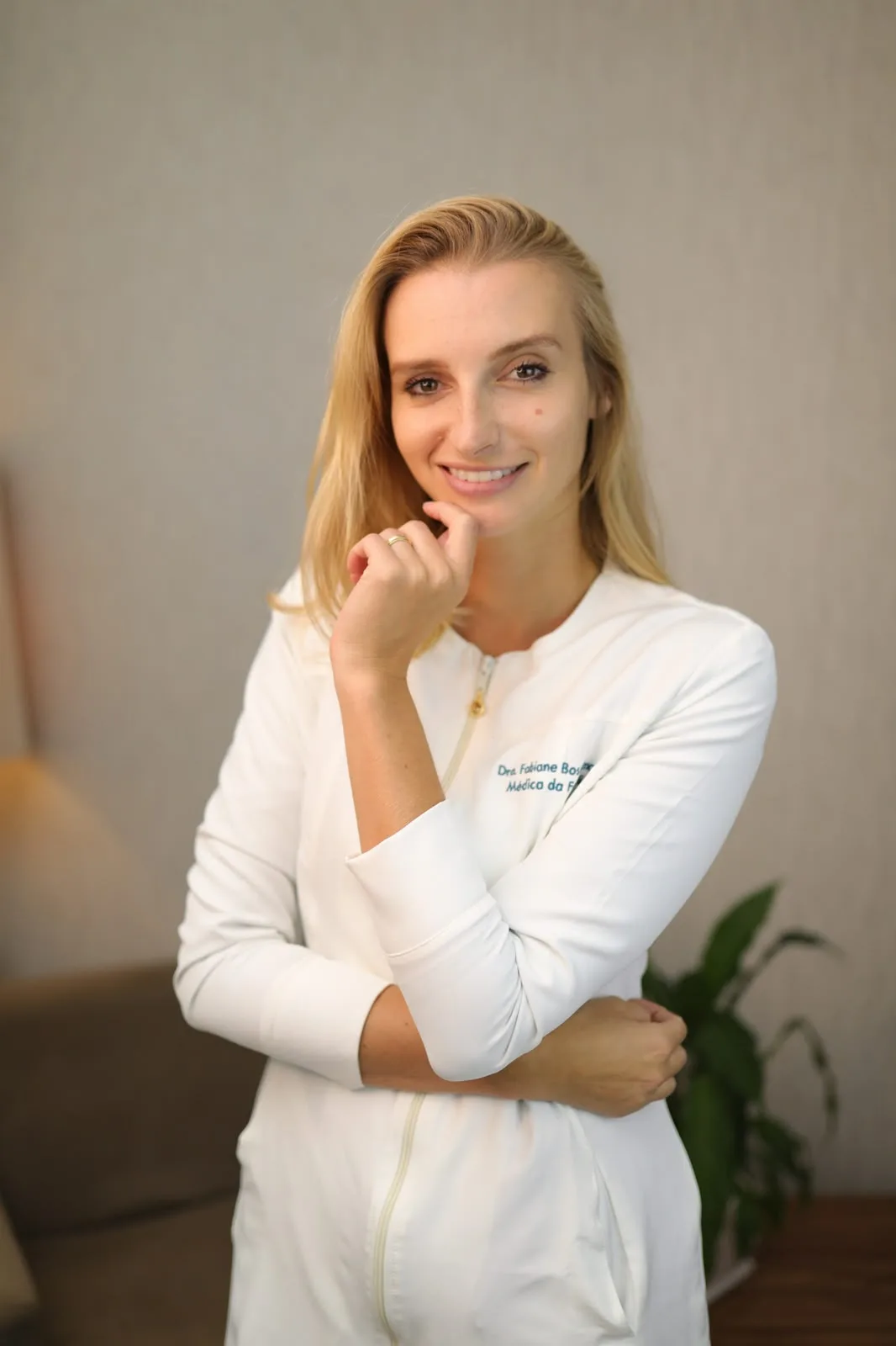 Dra. Fabiane Bostelmann de jaleco branco no consultório